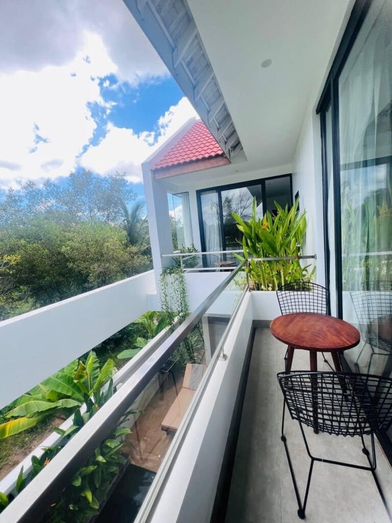 Spacious balcony of a 3-bedroom villa in Siem Reap with lush greenery and comfortable outdoor seating