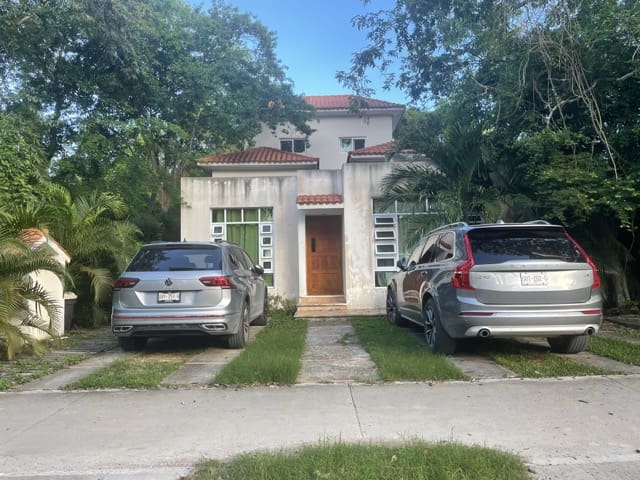 Real Estate Investment In Playa del Carmen: House and two cars in front of it Playacar house in high-end gated community