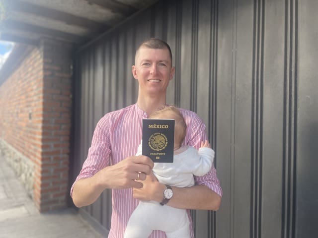 man with baby holding mexican passport