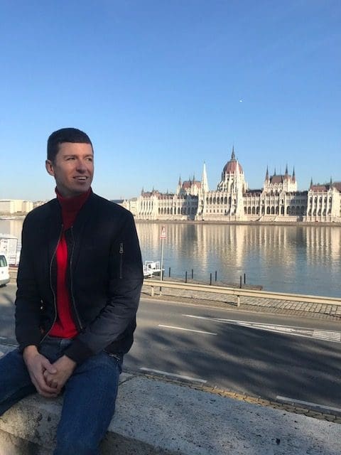 Ladislas Maurice sitting in front of Budapest parliament, prime real estate