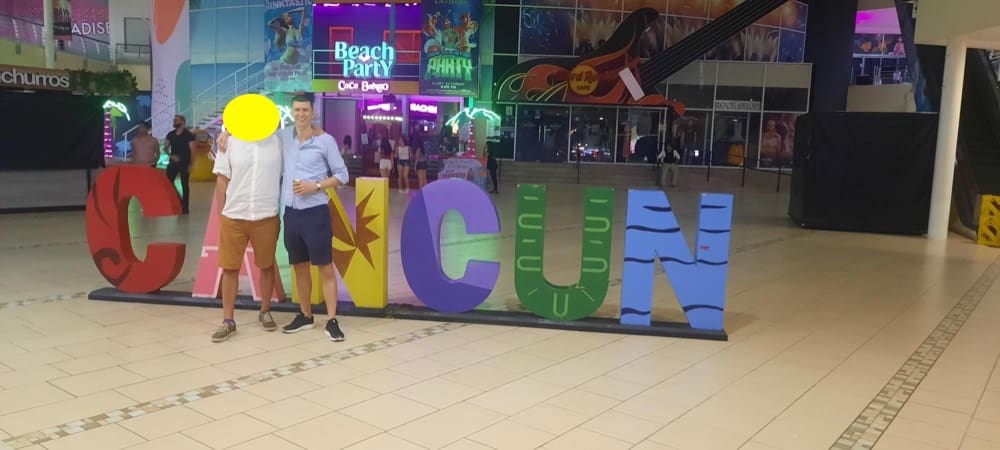 cancun sign in party area cancun with two men